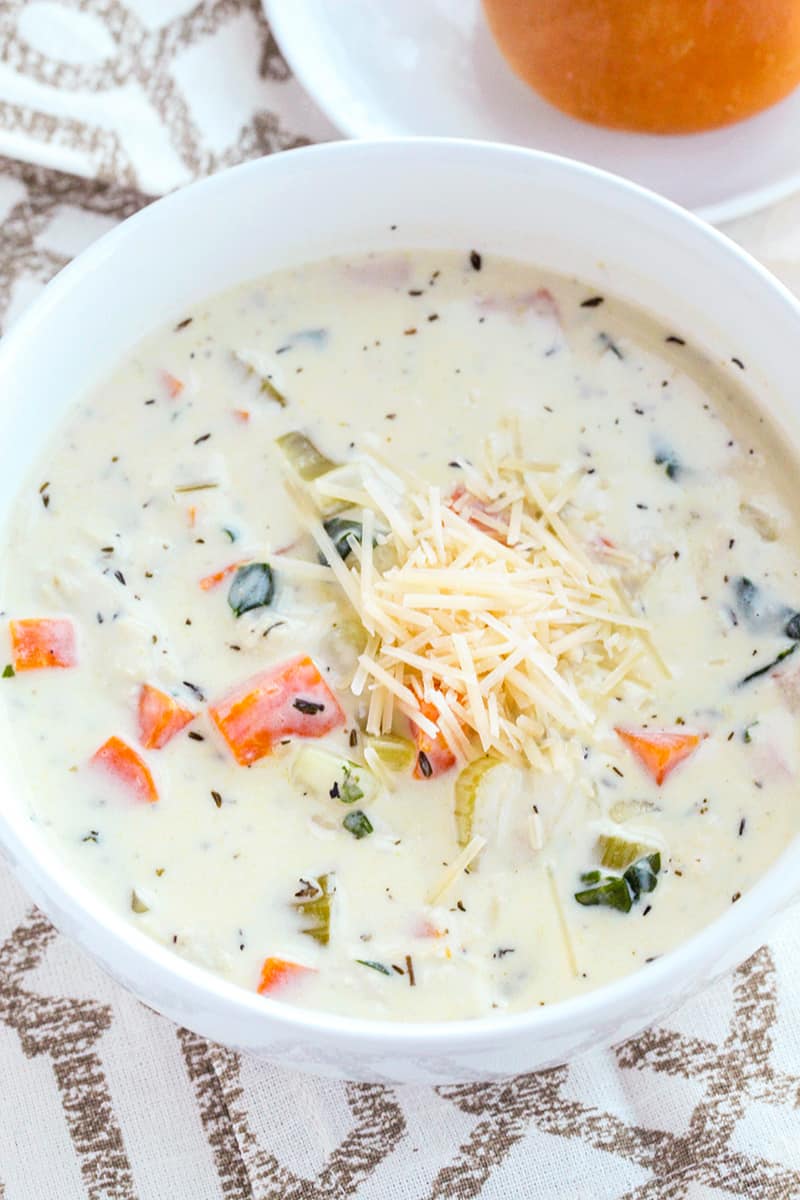 A bowl of chicken gnocchi soup with parmesan cheese on top