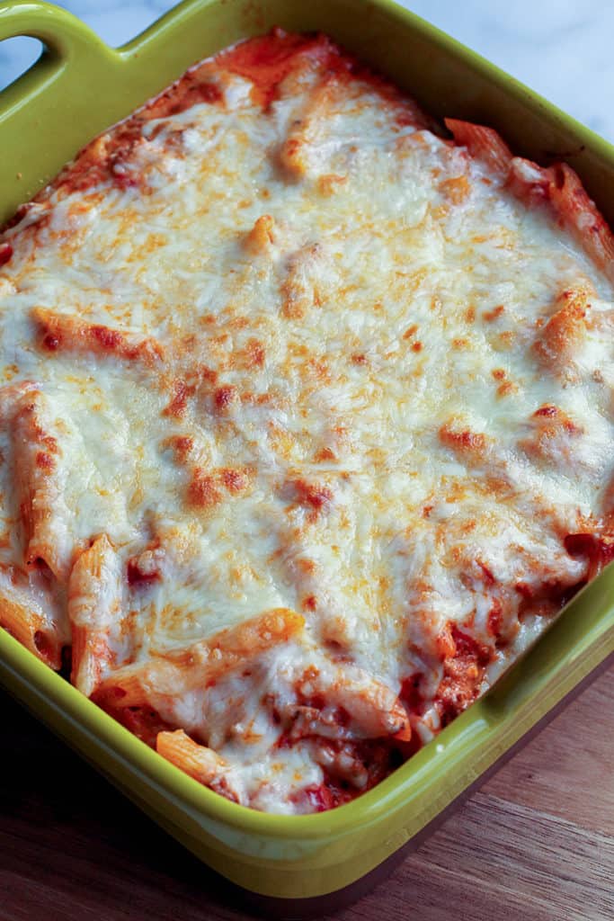 Casserole dish with creamy baked ziti and melted mozzarella cheese on top