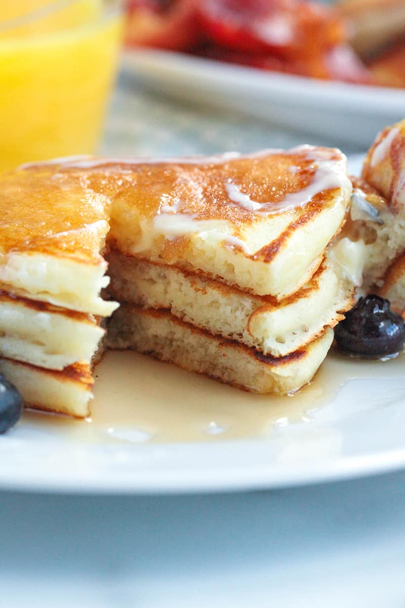 a stack of pancakes with a piece missing to show how fluffy they are