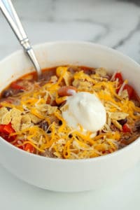 bowl of taco soup with sour cream and shredded cheese