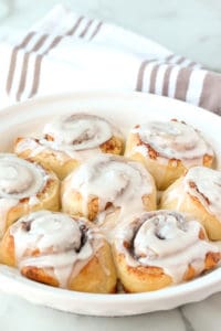 frozen bread dough made into easy cinnamon rolls with frosting in a pie plate
