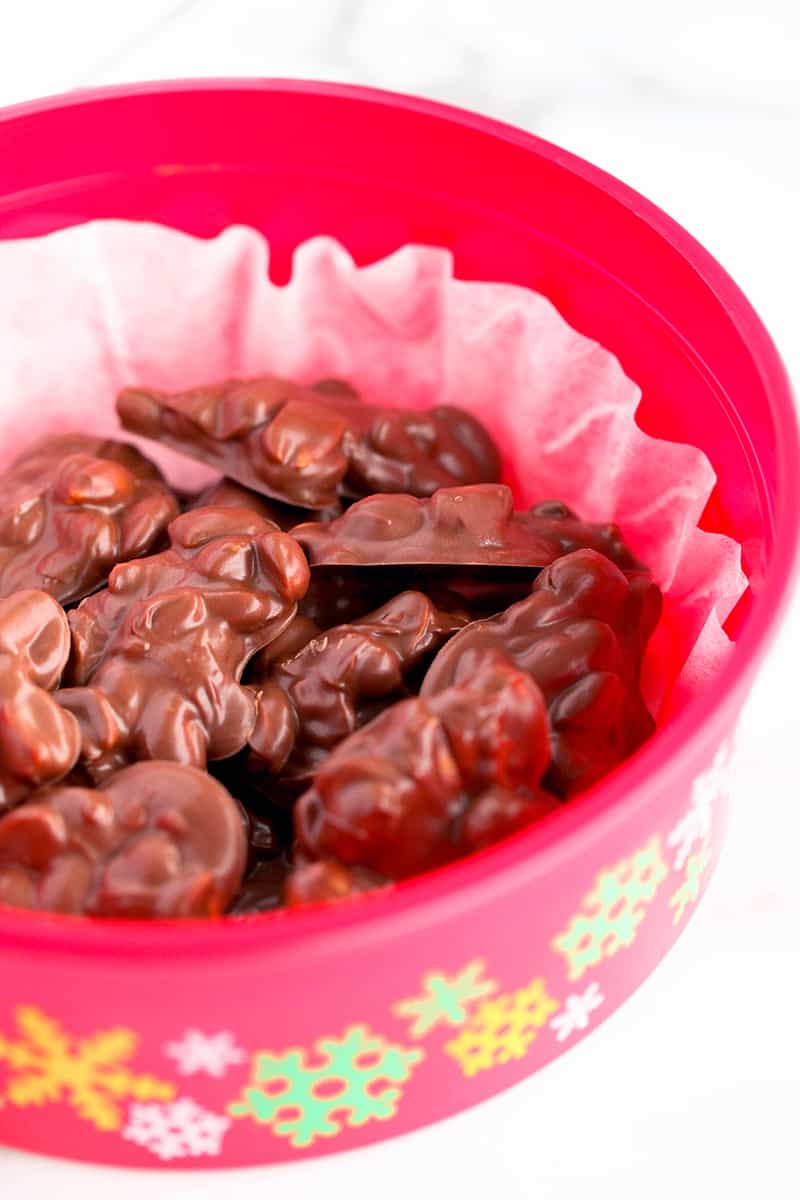 A plastic red bowl with colorful snowflakes on the sides and filled with crockpot candy