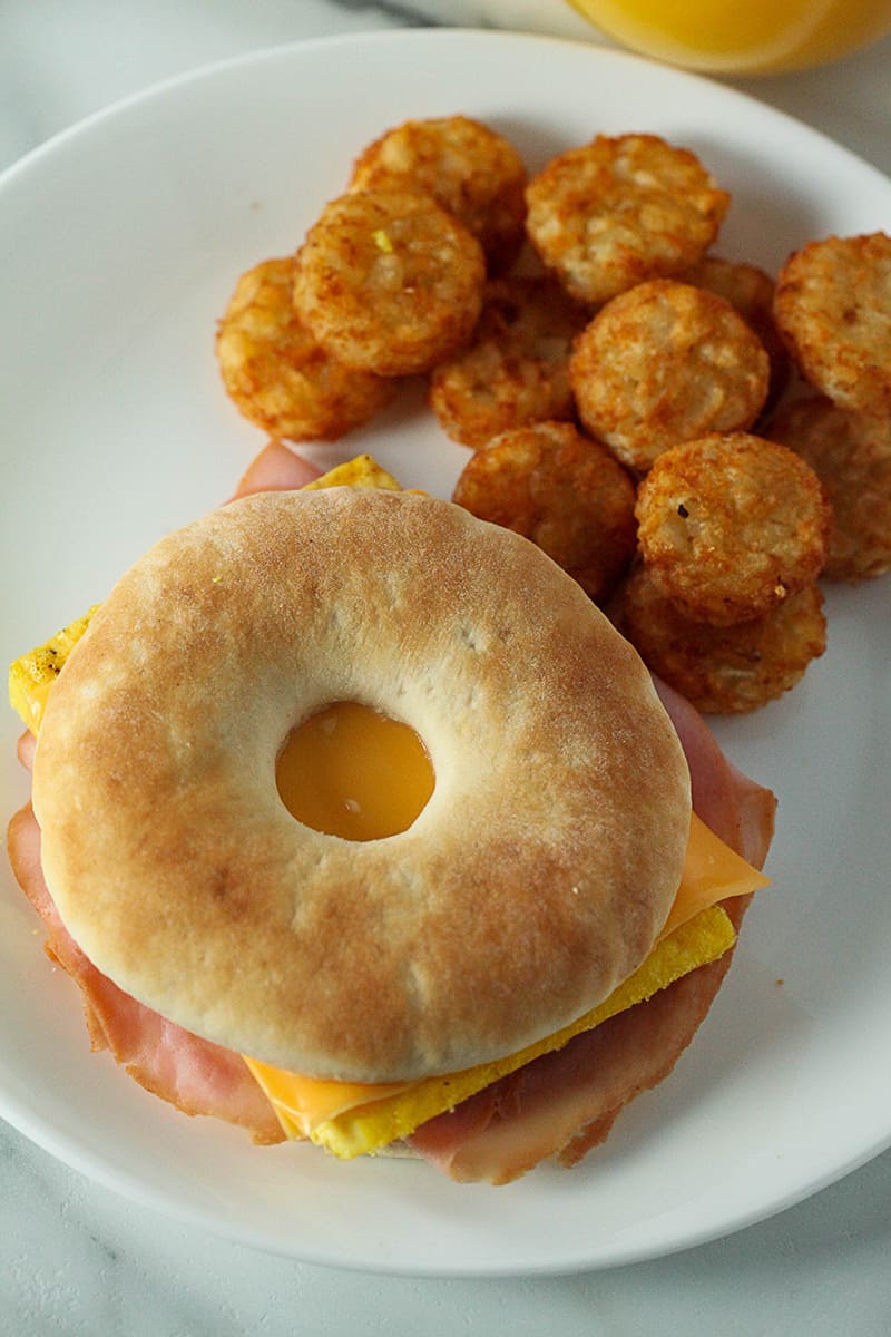 breakfast bagel sandwich with hash rounds on the side