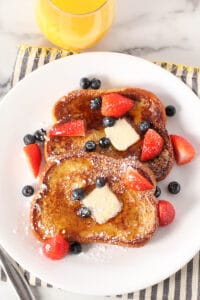 brioche french toast with fresh fruit and powdered sugar