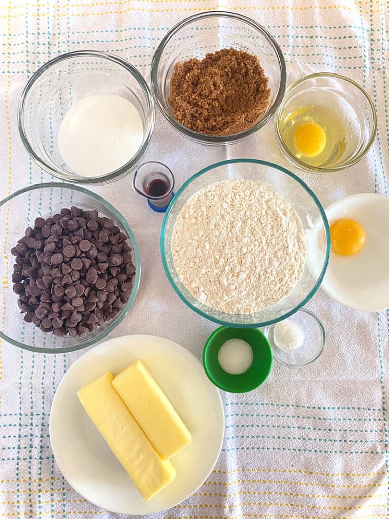 ingredients for chocolate chip cookies: flour, sugar, dark brown sugar, vanilla, egg, egg yolk, salt, baking soda and chocolate chips-from picsandpastries