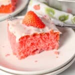 slice of strawberry cake from cake mix on a white plate with a strawberry on top of cake